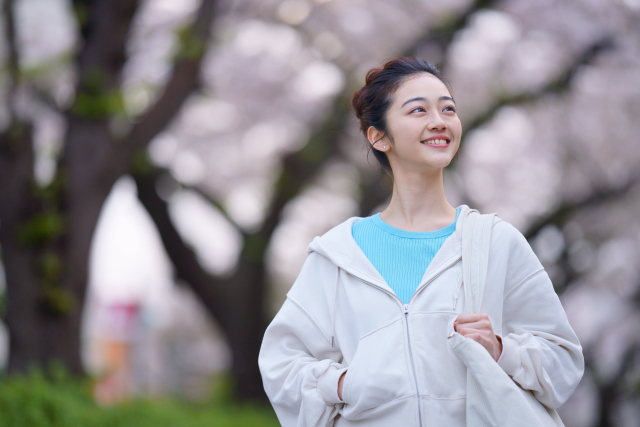 パーカーを着て歩く女性